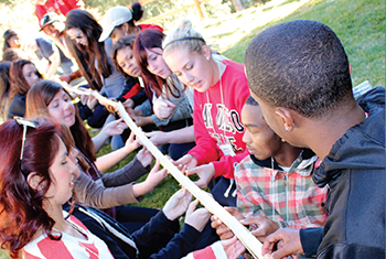 students in aztec core holding rope as a team building exercise